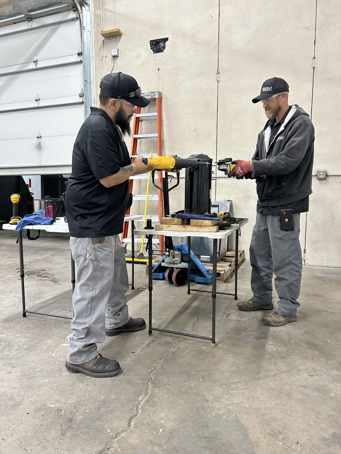Two SRV technicians working through a compressor job together at an SRV work bay in Colorado Springs