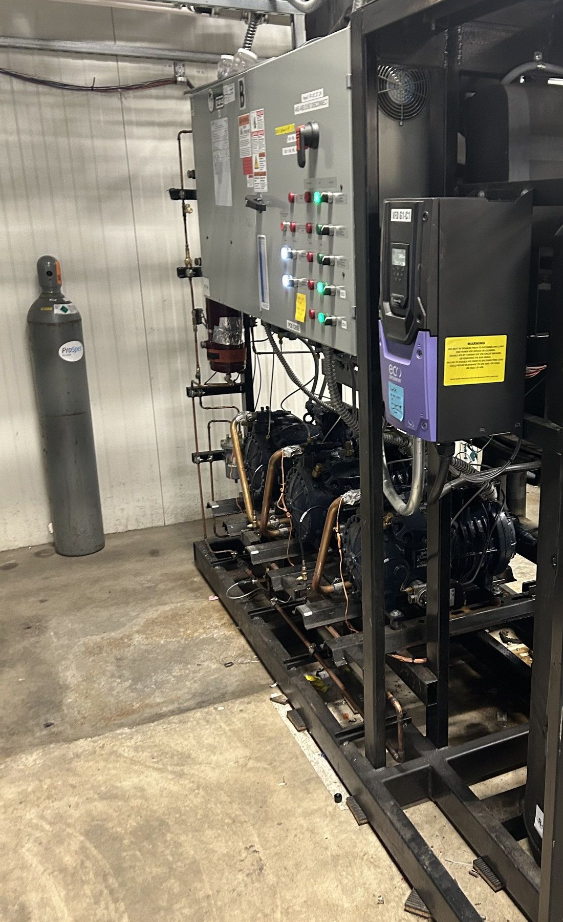 Multi-compressor refrigeration skid with its control panel and variable frequency drive in a mechanical room in St. George, Utah